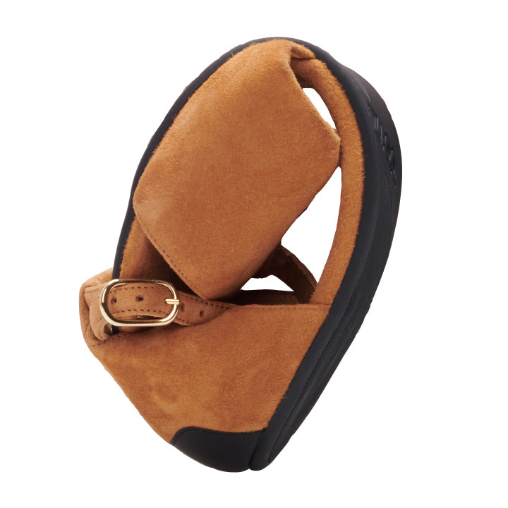 A TEQA Brown sandal from ZAQQ made of suede leather with a padded sole, gold buckle and ultra-thin, flexible sole is presented against a white background.