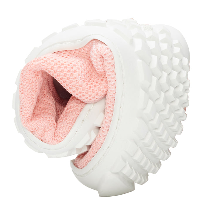 A close-up of the SUQAR pink sneaker from ZAQQ reveals a foldable design with a sophisticated sole. The interior is made of a pink, mesh-like material reminiscent of cotton knit, highlighting the shoe's flexibility and unique construction.