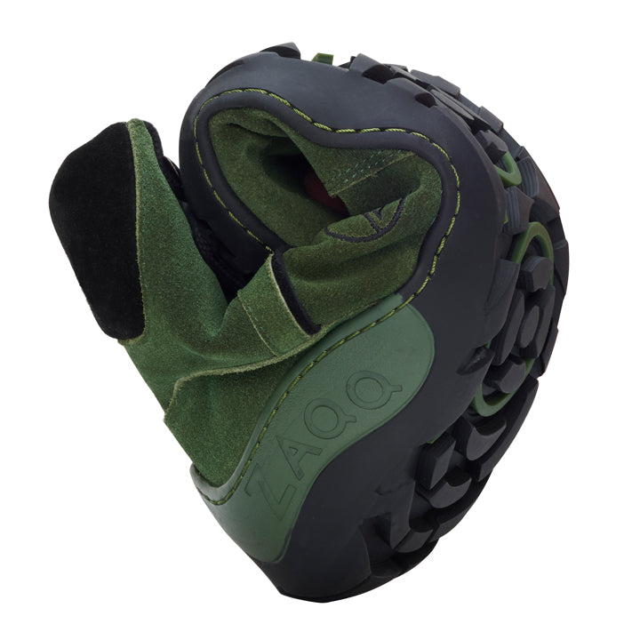 The TREQ Green Waterproof from ZAQQ is a green and black shoe with a flexible sole that easily twists into a compact shape. This outdoor barefoot shoe bears the brand name ZAQQ on the side and features the robust, structured profiles of the ZAQQ TERRA sole for improved grip.