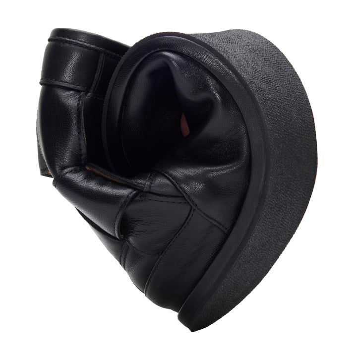 A couple ZAQQ LUQAS wide black wedge platform shoes, made of soft and flexible nappa leather, are folded and arranged to resemble a heart shape.