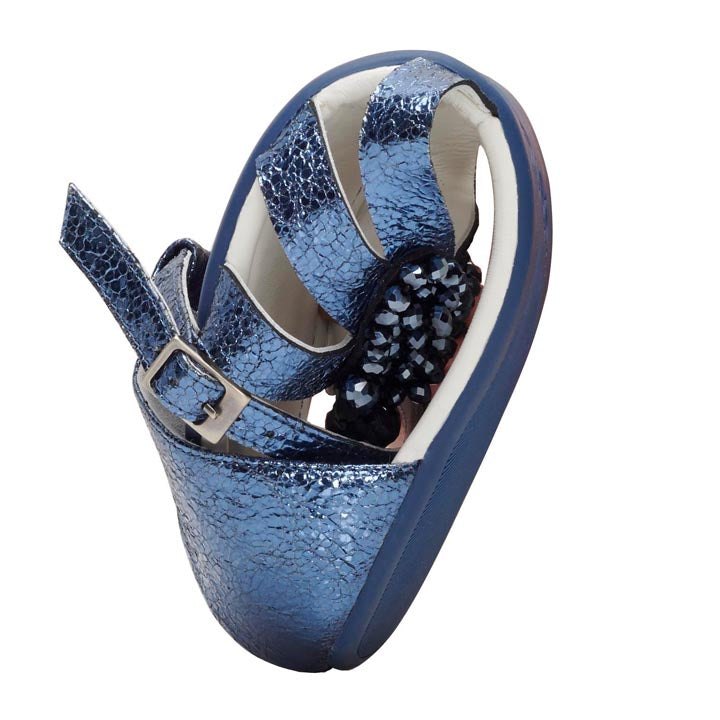 Introducing the QISELLE Blue orthopedic shoe from ZAQQ – a shiny metallic masterpiece with a curved sole and adjustable straps for ultimate support and comfort. This barefoot sandal-inspired design features a textured pattern, secure buckle, and delicate beaded accents to elevate your style.