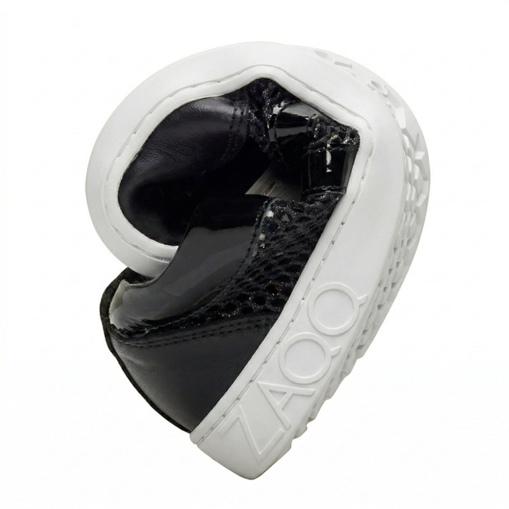 Ein schwarzer QIMBERLY-Schuh mit weißer Sohle ist kreisförmig gedreht dargestellt. Auf der Sohle ist der Markenname ZAQQ in erhabenen Buchstaben zu sehen. Das Schuhmaterial ist mit Lack- und Mesh-Details versehen, was den Schuh sowohl stylisch als auch atmungsaktiv macht.