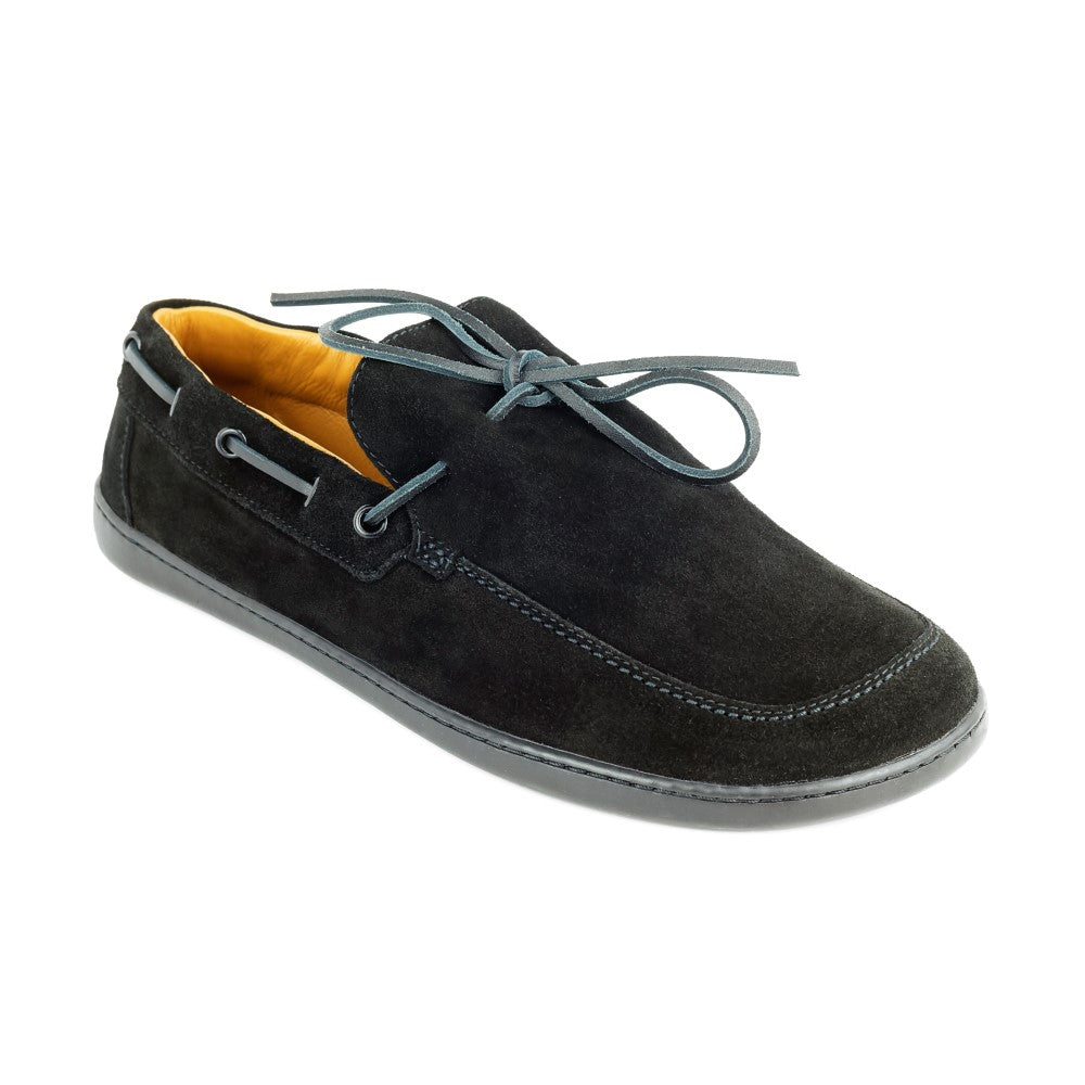 The QEA Velor Black from ZAQQ is an elegant, slightly left-leaning barefoot shoe with a structured rubber sole and lace-up details. Its black exterior contrasts with the bright orange interior for an eye-catching design.