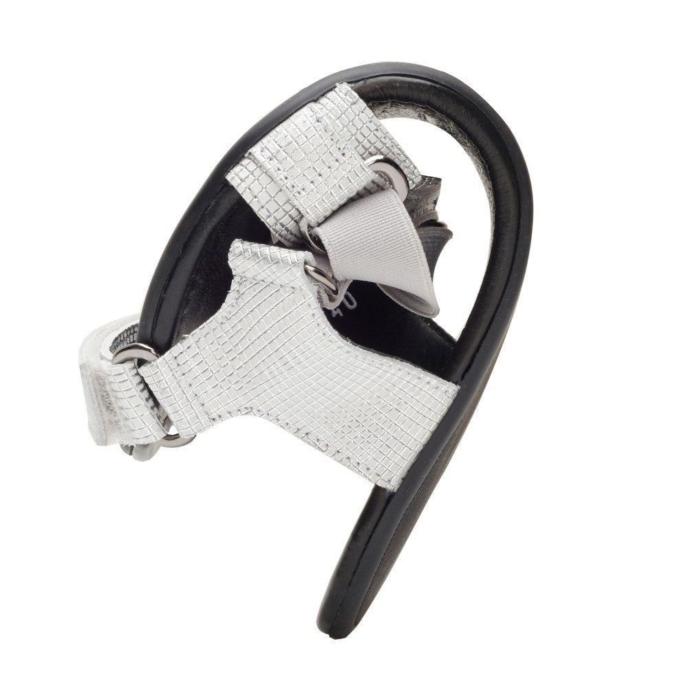 A single MIQA Silver shoe from ZAQQ is shown from the side, highlighting its textured silver upper decorated with metallic details and complemented by a black rubber sole. The design embodies a modern and minimalist aesthetic and highlights the distinctive strap and buckle detail.