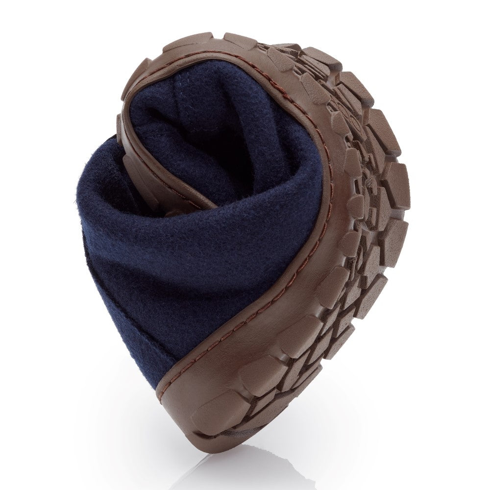 The QICE Blue shoe from ZAQQ is creatively folded in a heart shape and thus emphasizes its robust outdoor sole. The laces are hidden, showcasing the unique design and texture of these innovative barefoot shoes.