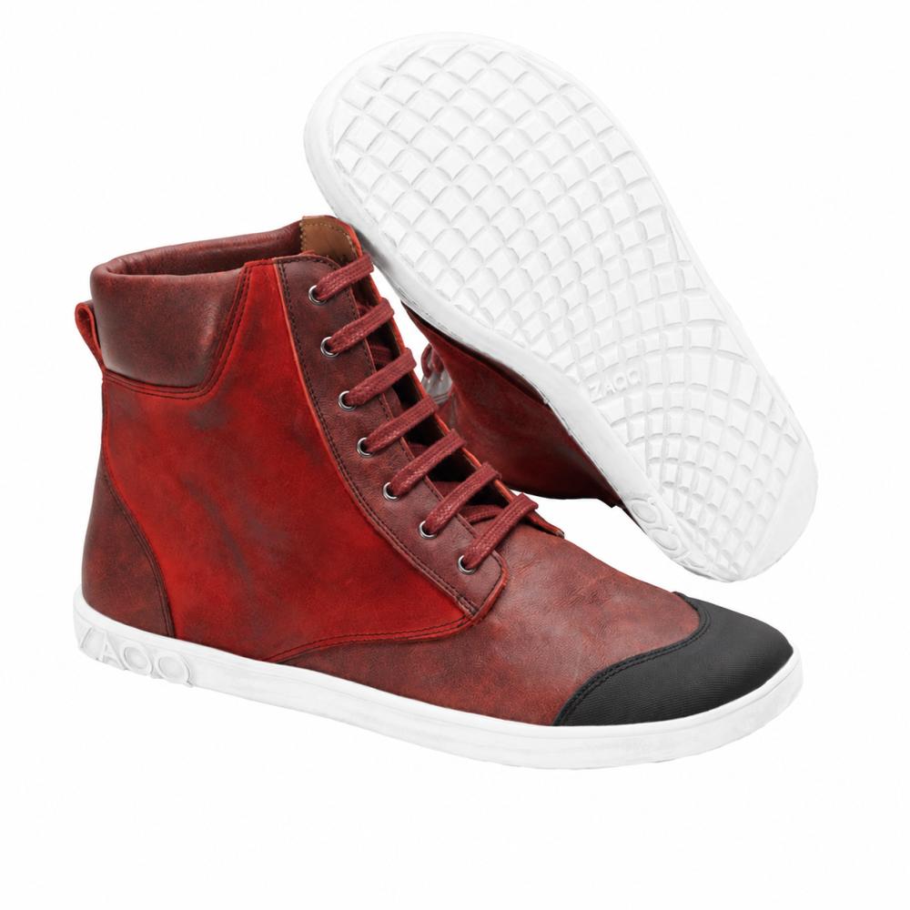 We present the CHICAQO Red by ZAQQ: These stylish high-top sneakers in vibrant red are crafted from high-quality nappa and suede leather. They have a smooth white sole and a striking black toe cap. One shoe stands upright, while the other is tilted to showcase its textured, flexible sole.