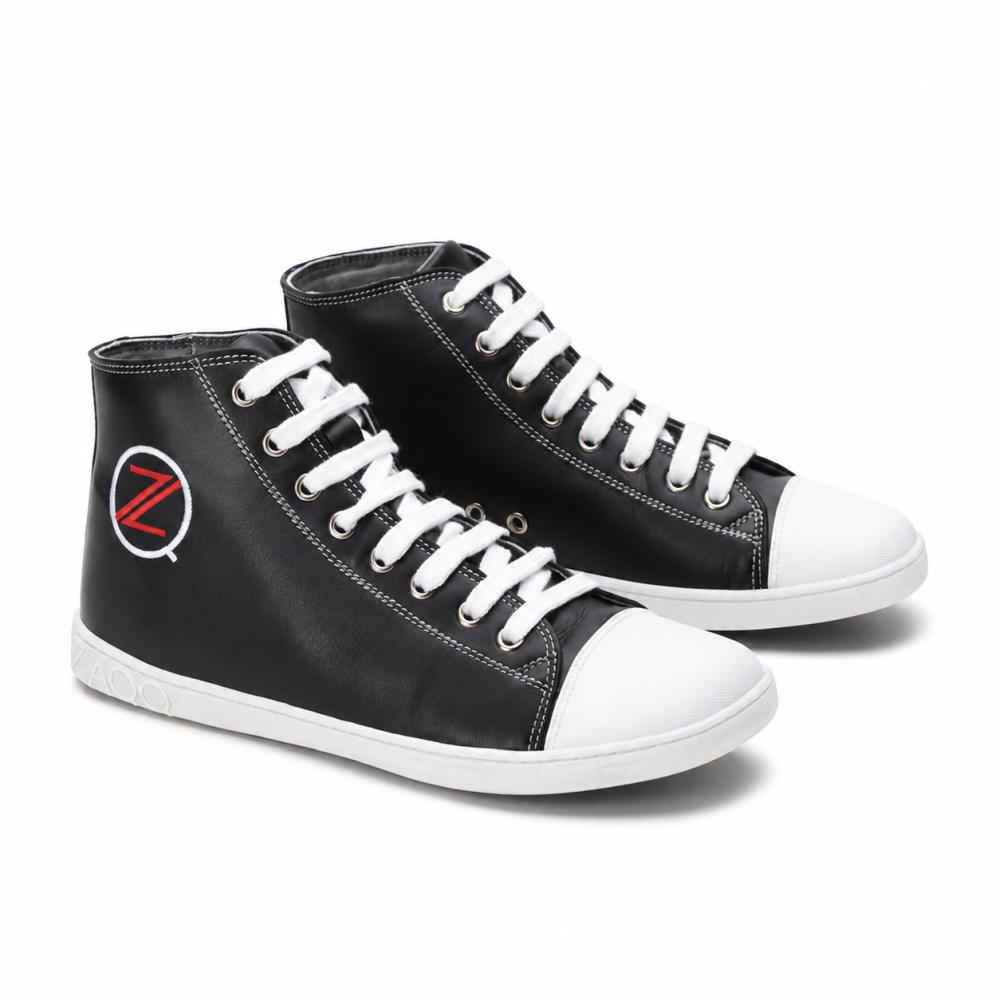 A pair of classic black high-top sneakers from ZAQQ CHUQQS features white laces and toe caps, each displaying a striking red and white Z-logo. The soles are made of durable rubber sole-gum, giving the shoes a trendy, slightly worn look.
