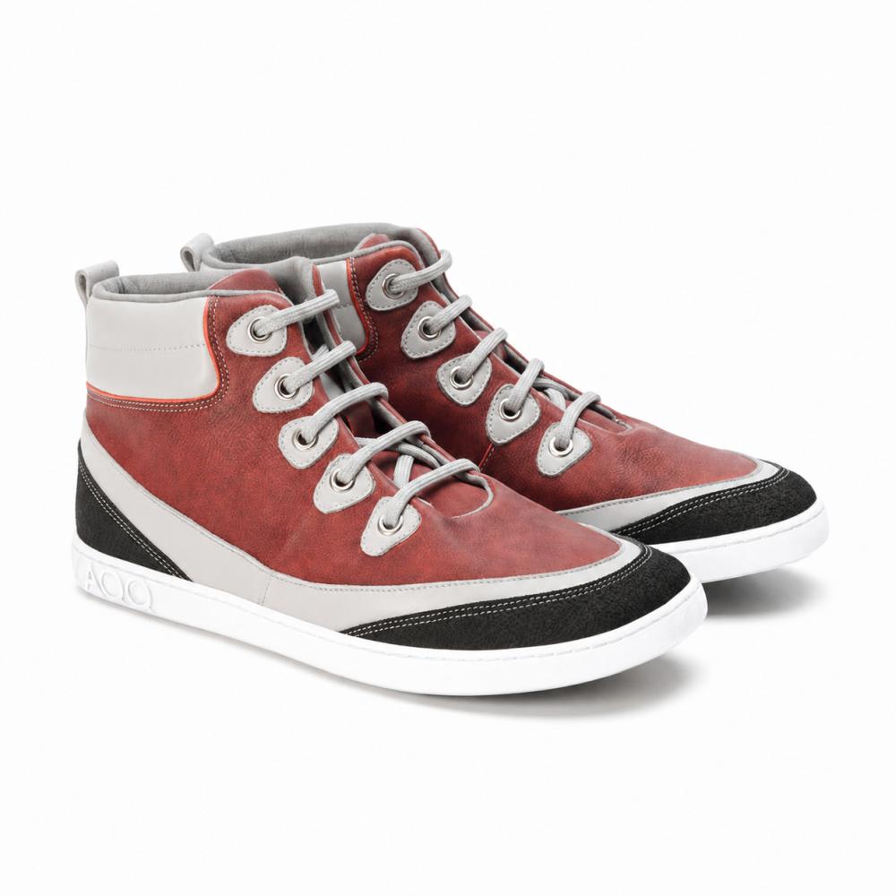 The ZAQQ CINQO Red High-Top Sneakers showcase a sporty design with red and white inserts, complemented by black textured accents. These shoes offer comfort with their white laces, patterned sole, and visible stitching for a seamless blend of style and comfort.