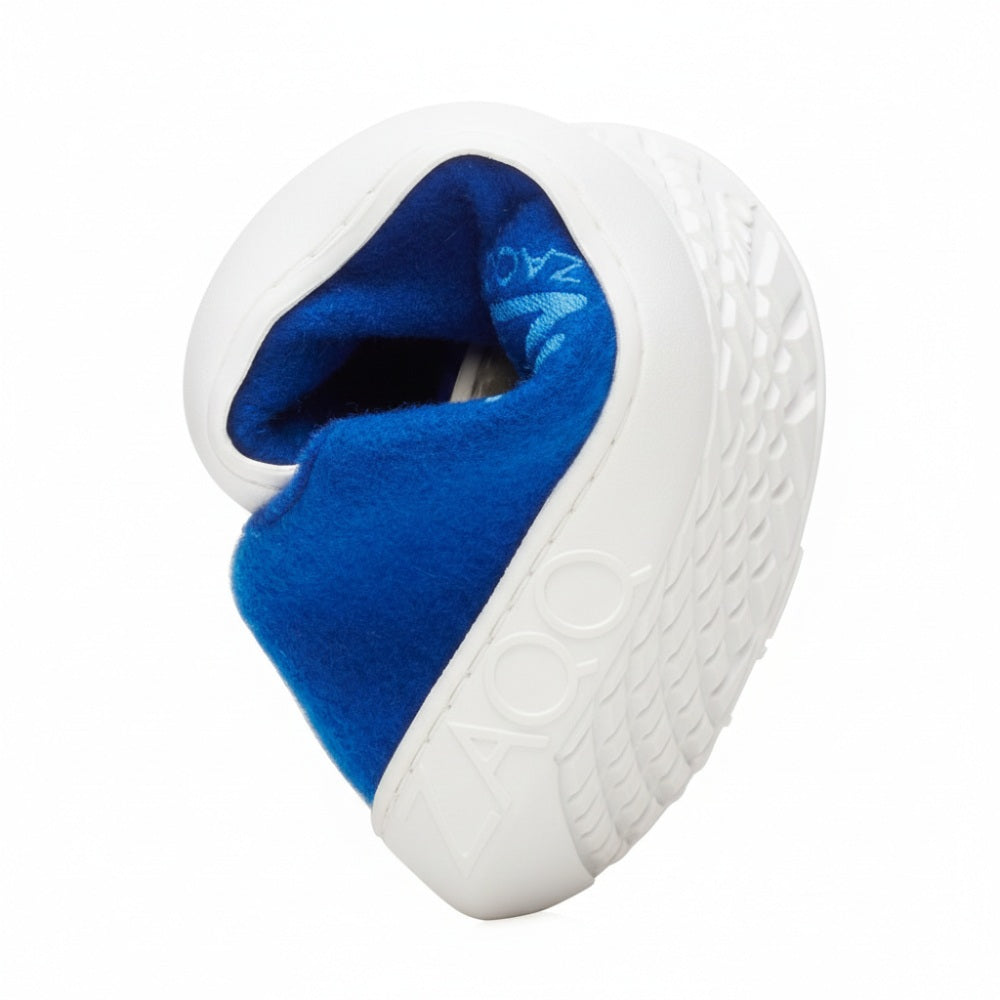 The popular LIQE Azur barefoot shoe from ZAQQ with a dirty, worn sole is bent into a heart. The bright blue merino wool lining contrasts beautifully with the exterior, which proudly displays the word ZOZO.