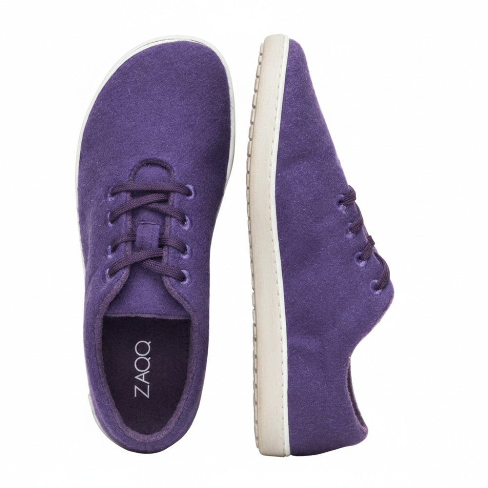 We present the LIQE Purple from ZAQQ: These sneakers feature an elegant, minimalist design, viewed both from above and from the side. They feature white soles ZAQQ-Branding and feature a barefoot sole for maximum comfort. The stylish purple laces add elegance and stand out beautifully against a pristine white background.