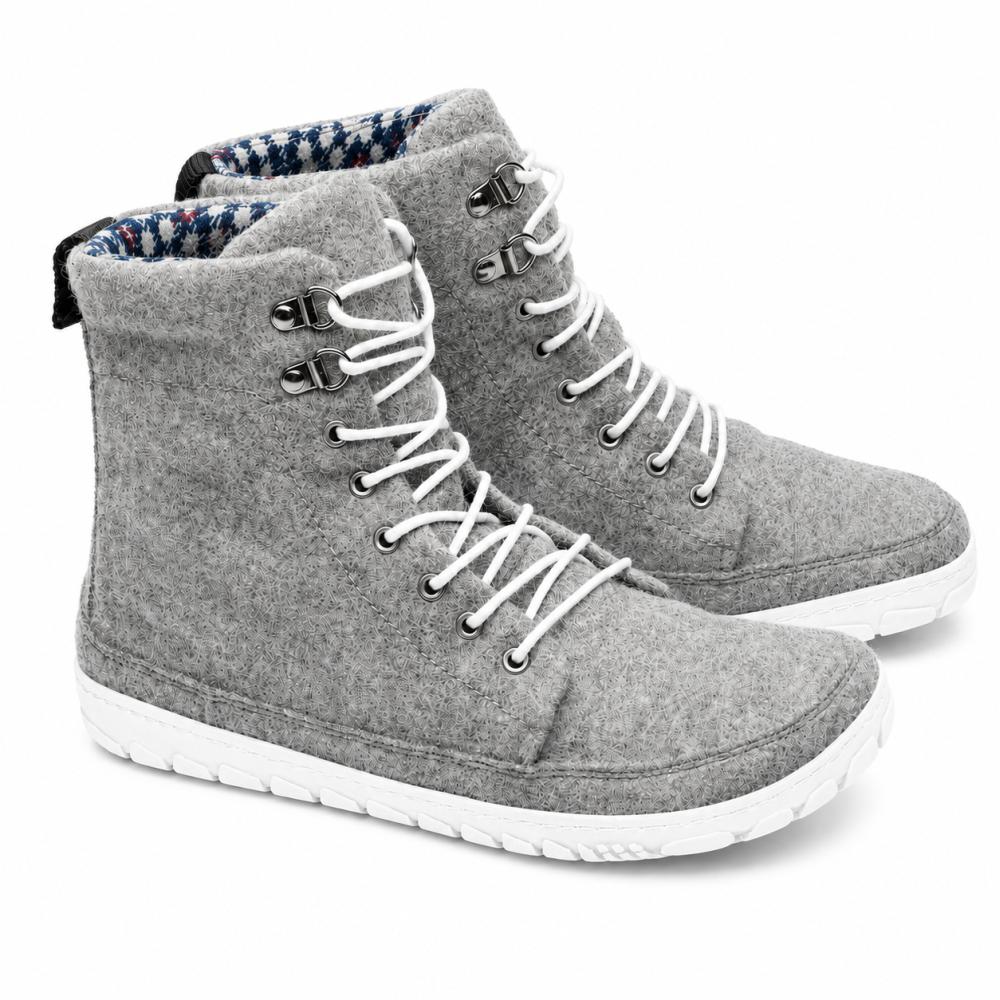 We present the QICE Grey from ZAQQ: a stylish pair of high-top felt sneakers in grey with white laces and sturdy white rubber soles. These sneakers feature an outdoor sole for better grip, complete with metal eyelets and a textured pattern on the outsole, making them ideal for any adventure.