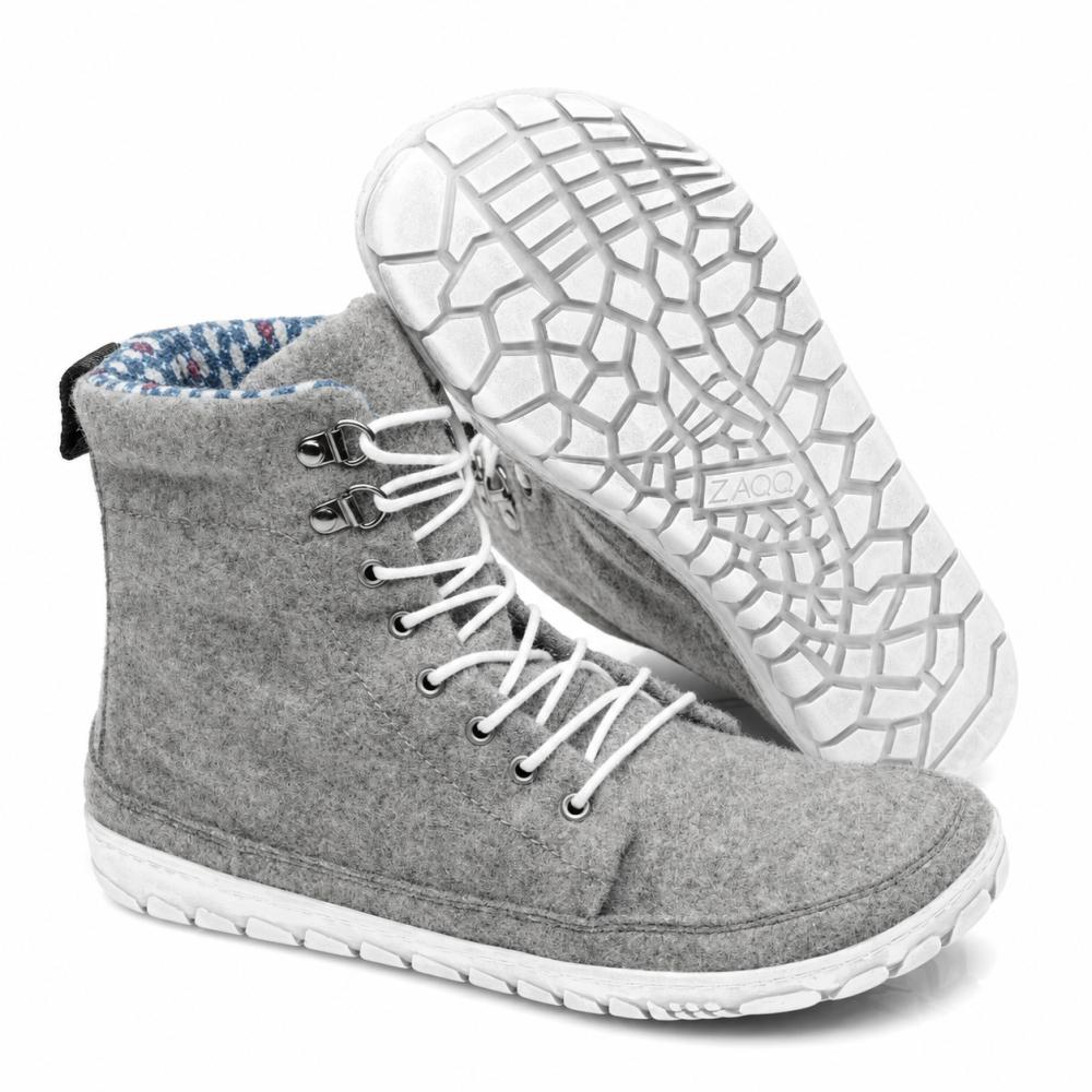 Displayed is a pair of QICE Grey high-top sneakers from ZAQQ with white laces. One shoe stands upright while the other is angled to highlight the textured, patterned outdoor sole.