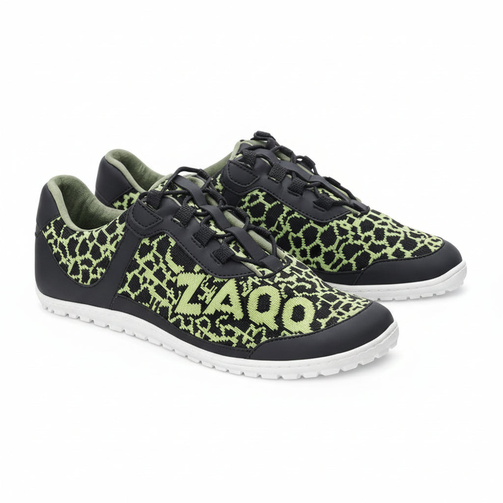 The QINGSTON Green sneakers from ZAQQ feature neon green geometric patterns with the number 2400 on the side, on an elegant black background. They feature white soles and black laces, all made from vegan materials, offering a distinctive design that stands out clearly against a crisp white background.