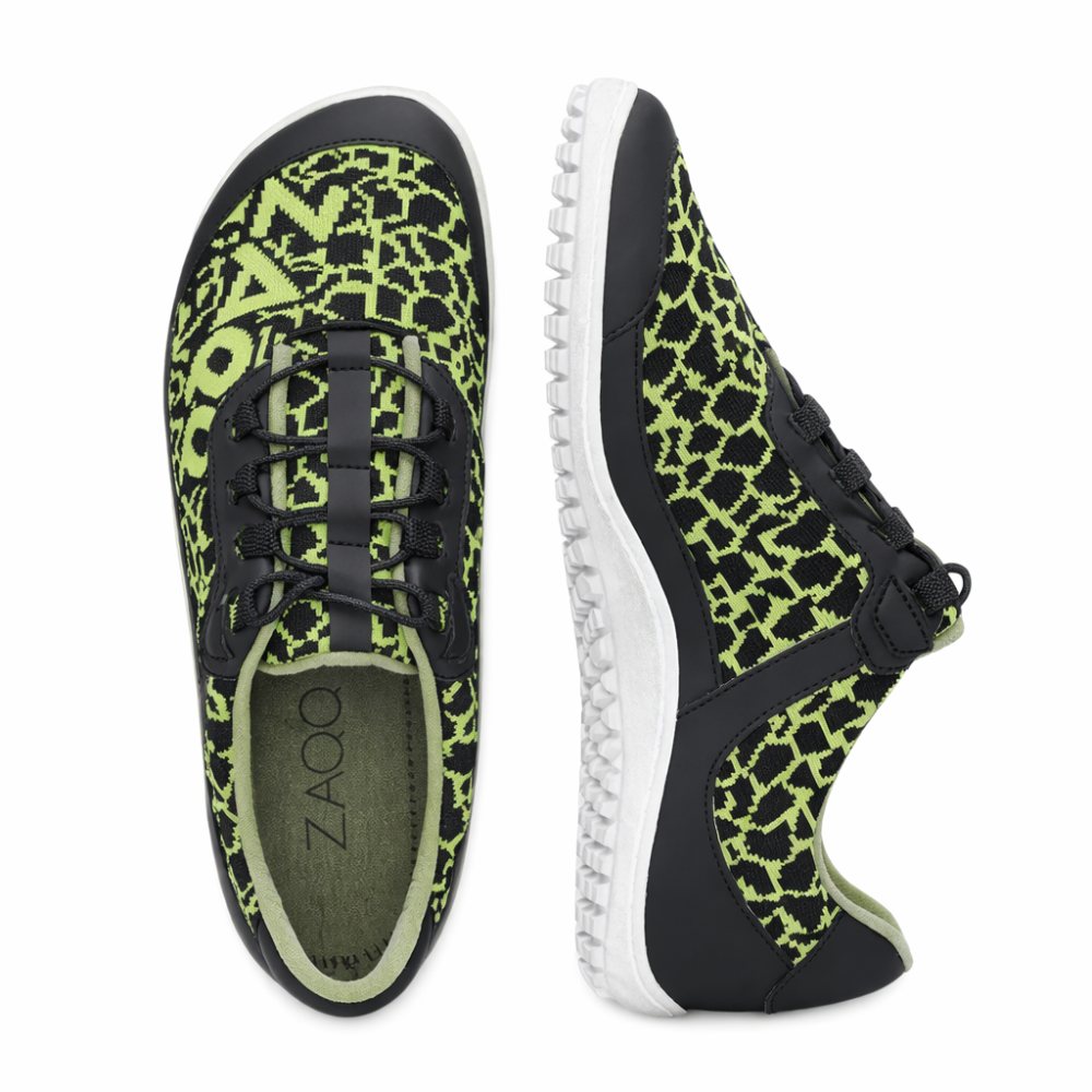 The QINGSTON Green sneakers from ZAQQ are shown in a top view and a side view and are characterized by a black and green pattern. Made from vegan materials, these shoes offer a lightweight, breathable design with a flexible sole and lace-up closure. The brand name ZAQQ is shown on the insole.