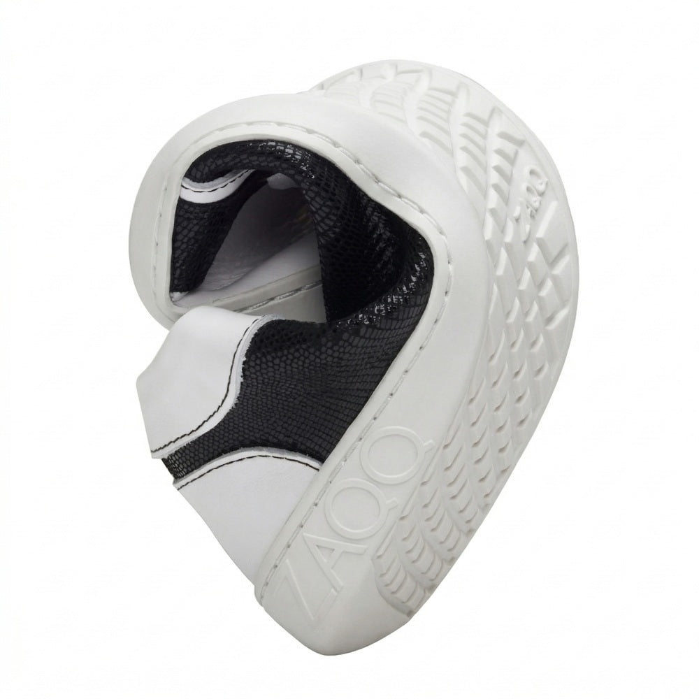 A flexible sole curved in the middle shows the tread pattern of this barefoot sneaker. The white outsole clearly bears the brand name ZAQQ, while the upper part of the QODY White shoe contrasts in black and white.