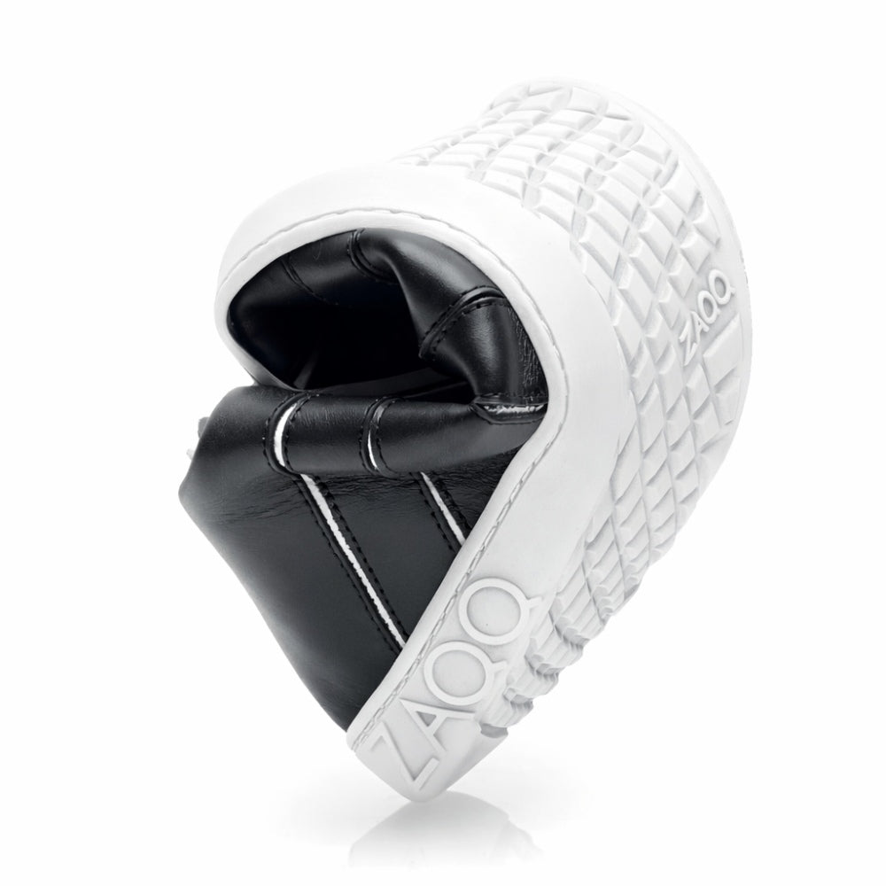 Close-up of the ZAQQ QQQ Mid Black White sneakers with an upward folded flexible sole. This elegant shoe is made from nappa leather, has a black design with a white textured sole and the brand name elegantly embossed on the side.