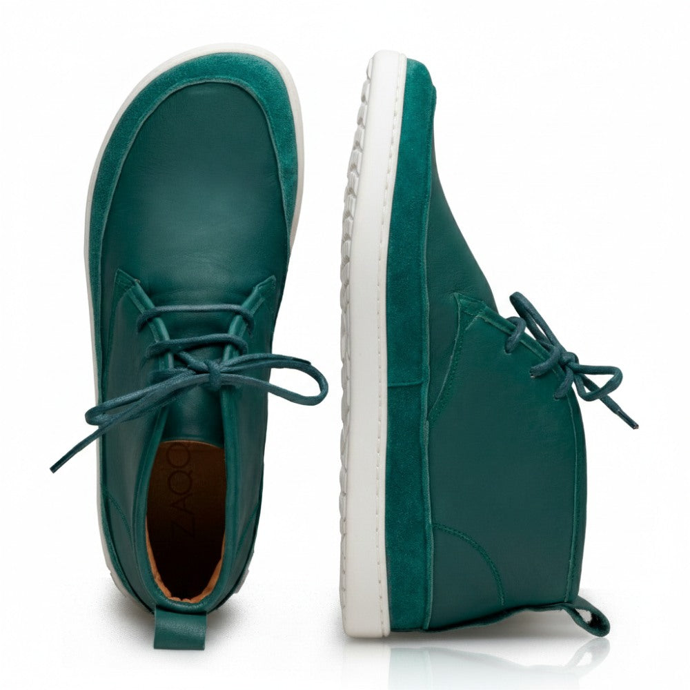 Ein Paar QUITMAN Green Leder-Sneaker in Blaugrün mit weißen Gummisohlen, einer von oben und der andere von der Seite betrachtet. Der seitliche Sneaker trägt die Prägung ZAQQ auf der Ferse und ist aus hochwertigem Velours- und Glattleder gefertigt, was ihm ein stilvolles Finish verleiht.