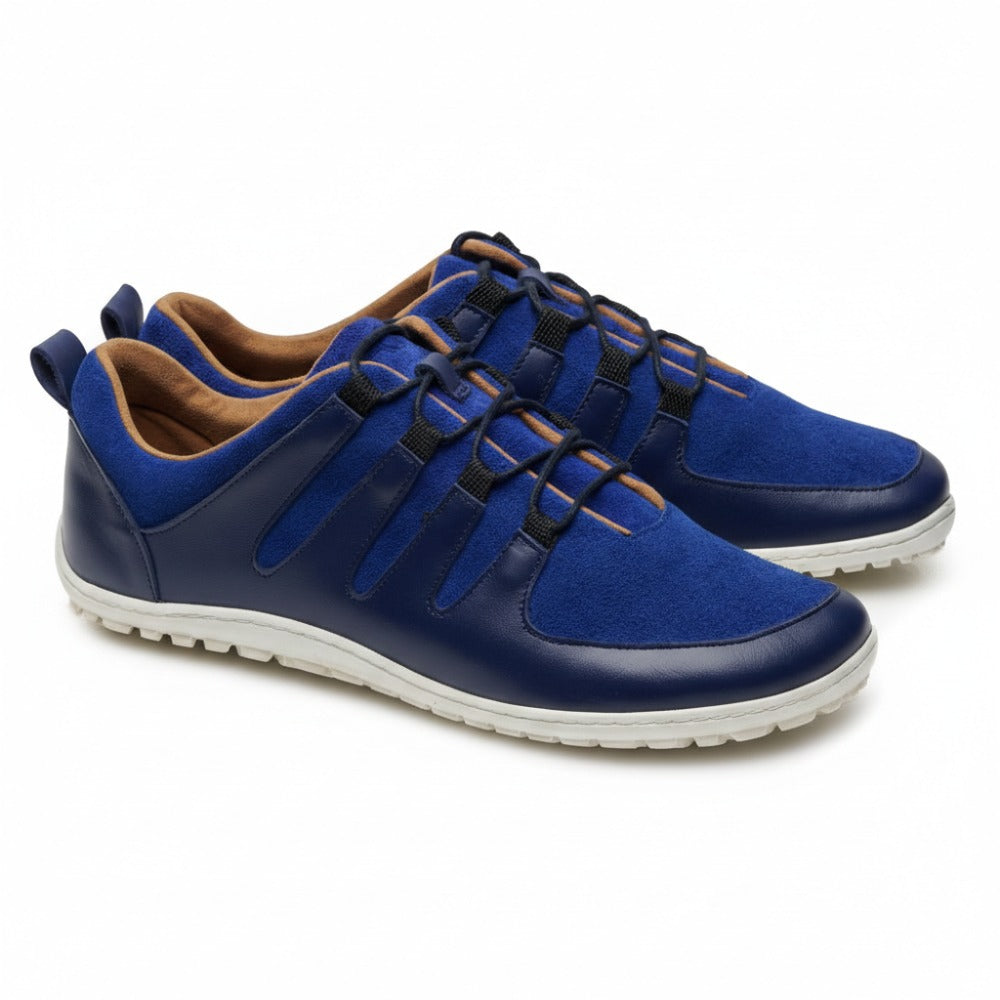 Introducing the SHOQQ Trident from ZAQQ, a pair of stylish blue sneakers made from a chic mix of suede and nappa leather. These barefoot sneakers feature unique lace and strap details, complemented by durable rubber soles for added comfort and flair.