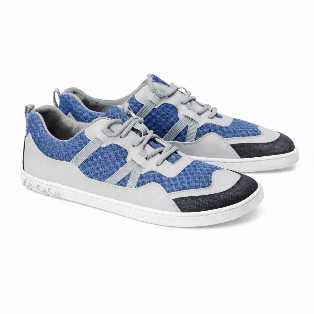 The SQOTT Blue sneakers from ZAQQ feature a blue-gray design with a honeycomb pattern that ensures a breathable feel. Featuring white soles and laces complemented by black accents on the toe and heel, these shoes offer both comfort and style with every step.