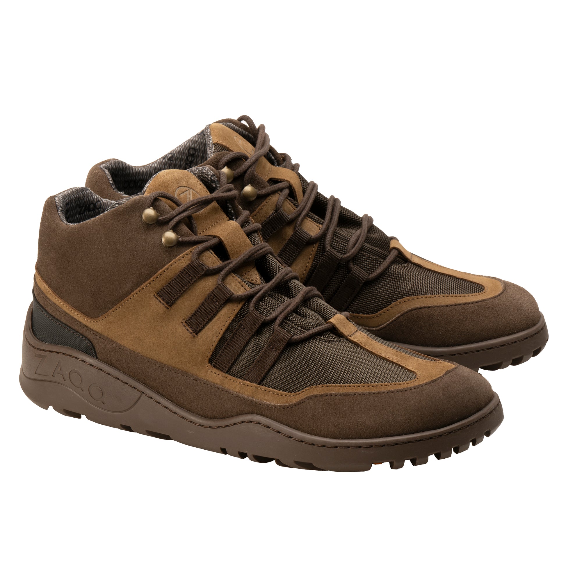 Wir präsentieren die braunen wasserdichten SQOUT-Stiefel von ZAQQ mit robuster ZAQQ TERRA-Sohle. Diese wasserdichten Wanderschuhe haben eine Schnürung vorne, eine Kombination aus Veloursleder und Mesh-Materialien sowie eine gepolsterte Knöchelstütze. Sie werden vor einem schlichten weißen Hintergrund präsentiert.