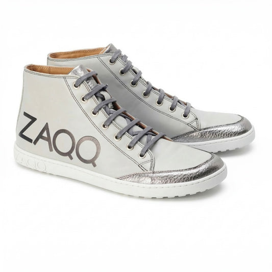 Entdecken Sie die ideale Kombination aus Stil und Komfort mit den SQYLA Grey High-Top-Sneakern von ZAQQ. Diese Sneaker sind mit silbernen Metallic-Akzenten und Markendetails verziert und aus hochwertigem Nappaleder gefertigt. Sie verfügen über ein klassisches Schnürdesign gepaart mit einer weißen Kautschuksohle, die für einen dezenten Used-Look sorgt.