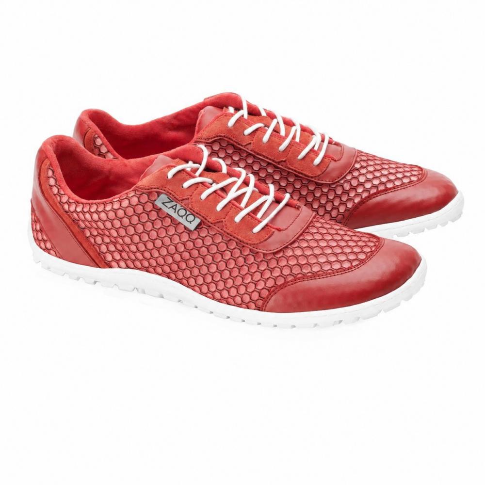 A pair of TOQIO Red Sneakers by ZAQQ, featuring an ultra-modern design with red upper material, accented by white laces and hexagonal mesh details. These shoes proudly display an elegant white sole and a brand logo tag on the side, elegantly positioned side by side on a flawlessly white background.