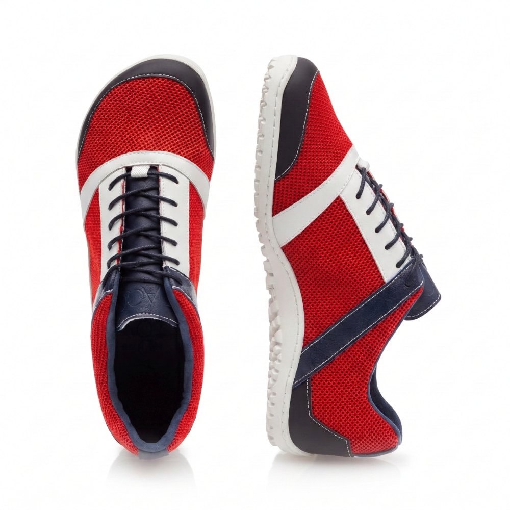 Wir präsentieren den ZARQA Red von ZAQQ: Ein Paar stylische, moderne Barfußschuhe aus leuchtend rotem Netzgewebe mit strahlend weißen Akzenten und einer edlen dunkelblauen Verzierung. Ein Schuh steht aufrecht, um die Seitenansicht zu präsentieren, während der andere die Draufsicht zeigt. Die Sohlen sind mit einem strukturierten Muster für besseren Halt versehen.