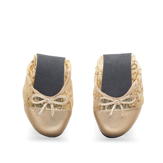 Nebeneinander ausgestellt sind die TWIST GUATEQUE Gold Ballerinas von ZAQQ mit paillettenbesetztem Mesh-Oberteil und glänzenden metallischen Zehenkappen. Jeder Schuh hat oben eine kleine Schleife, eine flexible Sohle und schwarze Gummibänder in der Mitte für einen sicheren Sitz und zusätzlichen Komfort.